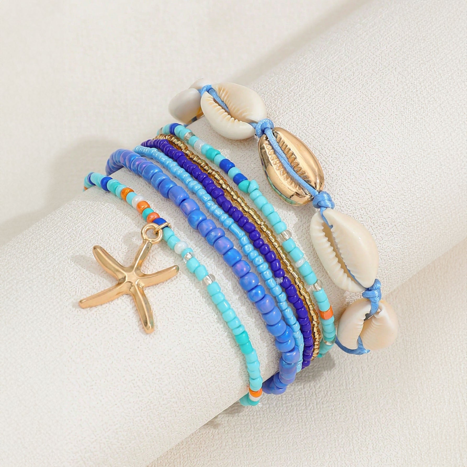 طقم أساور بوهيمي – خرز أزرق مع صدف وتعليقة نجمة بحر، لمسة صيفية جذّابة - 7 قطع - AMZ6111